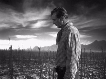 Movie still from “The Westerner” (1940), directed by William Wyler – A black and white photo of a man standing in the middle of a field; Medium shot, Low angle