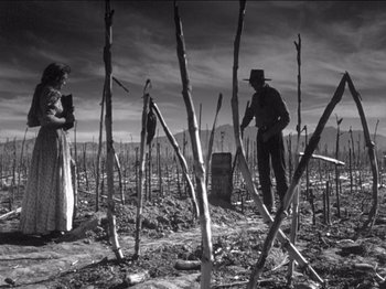 Movie still from “The Westerner” (1940), directed by William Wyler – A man and a woman standing next to a tree; Wide shot, Low angle