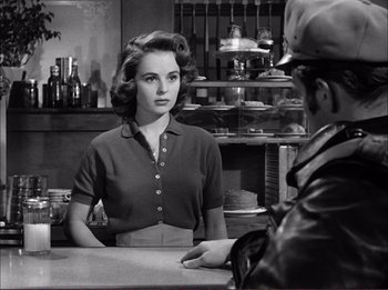 Movie still from “The Wild One” (1953), directed by Laslo Benedek – A woman sitting at a counter in a restaurant; Medium shot, Over the shoulder angle