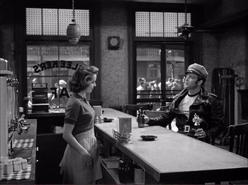 Movie still from “The Wild One” (1953), directed by Laslo Benedek – A man and a woman at a counter in a restaurant; Medium shot, Over the shoulder angle