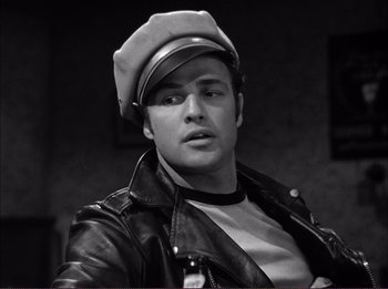 Movie still from “The Wild One” (1953), directed by Laslo Benedek – Black and white photograph of a man wearing a hat; Close Up shot, Low angle