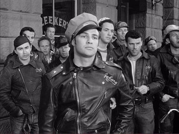 Movie still from “The Wild One” (1953), directed by Laslo Benedek – Black and white photograph of men in leather jackets; Medium shot, Low angle