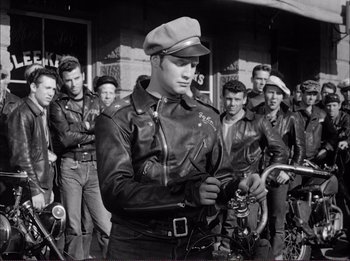Movie still from “The Wild One” (1953), directed by Laslo Benedek – Black and white photograph of a man in a leather jacket; Medium shot, Low angle