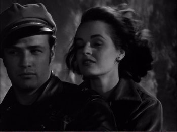 Movie still from “The Wild One” (1953), directed by Laslo Benedek – A man and a woman in leather jackets and hats; Close Up shot, High angle