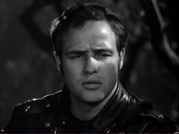 Movie still from “The Wild One” (1953), directed by Laslo Benedek – Black and white photograph of a man wearing a leather jacket; Close Up shot, Low angle