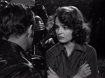 Movie still from “The Wild One” (1953), directed by Laslo Benedek – A man and a woman standing next to each other in front of a motorcycle; Close Up shot, Over the shoulder angle