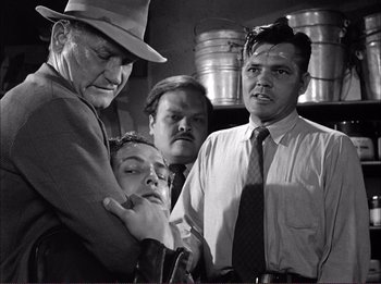 Movie still from “The Wild One” (1953), directed by Laslo Benedek – A black and white photo of a group of people; Medium shot, Over the shoulder angle