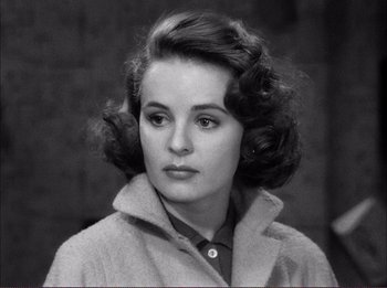 Movie still from “The Wild One” (1953), directed by Laslo Benedek – A black and white photo of a woman in a coat; Close Up shot, High angle