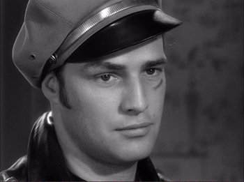 Movie still from “The Wild One” (1953), directed by Laslo Benedek – Black and white photograph of a man wearing a hat; Close Up shot, Low angle