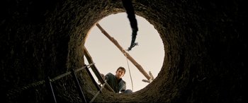 Movie still from “The Wild Pear Tree” (2018), directed by Nuri Bilge Ceylan – A man climbing up the side of a building; Wide shot, Low angle