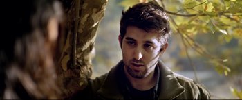 Movie still from “The Wild Pear Tree” (2018), directed by Nuri Bilge Ceylan – A person wearing a jacket near a tree; Close Up shot, Low angle