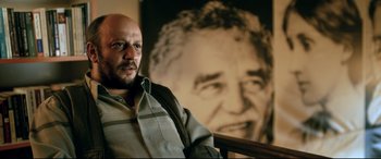 Movie still from “The Wild Pear Tree” (2018), directed by Nuri Bilge Ceylan – A man sitting in front of a picture of a man; Close Up shot, Low angle