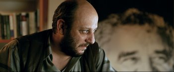 Movie still from “The Wild Pear Tree” (2018), directed by Nuri Bilge Ceylan – A man with a bald head is looking at the camera; Close Up shot, Low angle