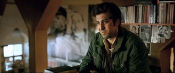 Movie still from “The Wild Pear Tree” (2018), directed by Nuri Bilge Ceylan – A man sitting in front of a picture of a woman; Close Up shot, Low angle