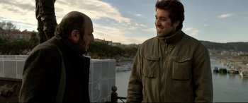 Movie still from “The Wild Pear Tree” (2018), directed by Nuri Bilge Ceylan – Two men are standing next to each other talking; Medium shot, Over the shoulder angle