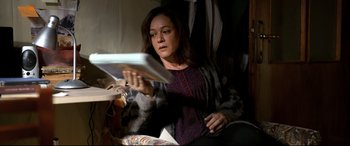 Movie still from “The Wild Pear Tree” (2018), directed by Nuri Bilge Ceylan – A woman sitting in a chair reading a newspaper; Medium shot, High angle
