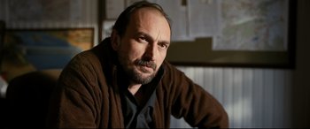 Movie still from “The Wild Pear Tree” (2018), directed by Nuri Bilge Ceylan – A person sitting in a room; Close Up shot, Low angle