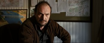 Movie still from “The Wild Pear Tree” (2018), directed by Nuri Bilge Ceylan – A man with a beard and mustache wearing a brown jacket; Close Up shot, Low angle