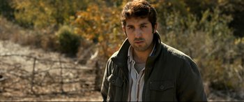 Movie still from “The Wild Pear Tree” (2018), directed by Nuri Bilge Ceylan – A man with a beard wearing a green jacket; Close Up shot, Over the shoulder angle