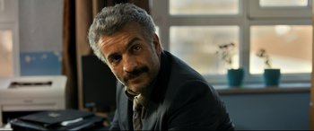 Movie still from “The Wild Pear Tree” (2018), directed by Nuri Bilge Ceylan – A person wearing a suit and tie; Close Up shot, Over the shoulder angle