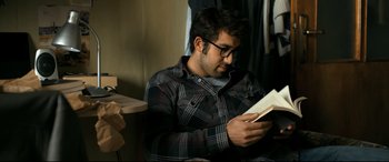 Movie still from “The Wild Pear Tree” (2018), directed by Nuri Bilge Ceylan – A man reading a book in a room; Medium shot, Over the shoulder angle