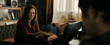 Movie still from “The Wild Pear Tree” (2018), directed by Nuri Bilge Ceylan – A woman sitting on a chair in a living room; Medium shot, Over the shoulder angle