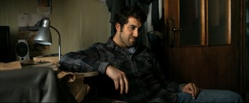 Movie still from “The Wild Pear Tree” (2018), directed by Nuri Bilge Ceylan – A man sitting in a chair in a room; Medium shot, High angle