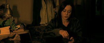 Movie still from “The Wild Pear Tree” (2018), directed by Nuri Bilge Ceylan – A woman sitting on a couch looking down at her cell phone; Medium shot, High angle