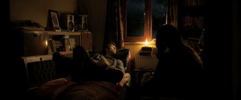 Movie still from “The Wild Pear Tree” (2018), directed by Nuri Bilge Ceylan – A man laying on a bed in front of a window at night; Medium shot, Over the shoulder angle