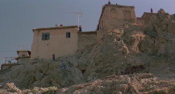 Movie still from “The Wind Will Carry Us” (1999), directed by Abbas Kiarostami – A group of people standing on top of a rock formation; Extreme Wide shot, Low angle