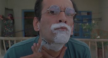 Movie still from “The Wind Will Carry Us” (1999), directed by Abbas Kiarostami – A man is shaving his face with a razor; Close Up shot, Low angle