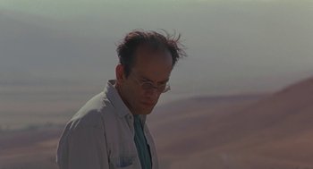 Movie still from “The Wind Will Carry Us” (1999), directed by Abbas Kiarostami – A man in a white shirt and a blue tie; Close Up shot, Low angle