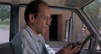 Movie still from “The Wind Will Carry Us” (1999), directed by Abbas Kiarostami – A man sitting in a car looking at his cell phone; Close Up shot, Low angle