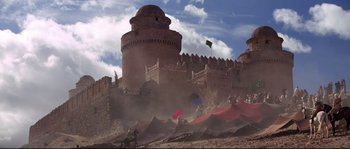 Movie still from “The Wind and the Lion” (1975), directed by John Milius – A castle with a flag flying in the background; Extreme Wide shot, Low angle