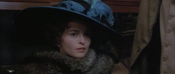 Movie still from “The Wings of the Dove” (1997), directed by Iain Softley – A woman in a blue hat and a fur coat; Close Up shot, Over the shoulder angle
