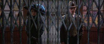 Movie still from “The Wings of the Dove” (1997), directed by Iain Softley – A man and a woman standing next to each other behind a fence; Medium shot, Low angle