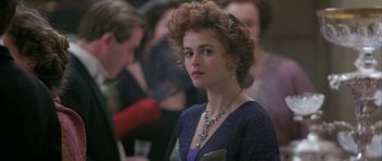 Movie still from “The Wings of the Dove” (1997), directed by Iain Softley – A person with curly hair wearing a necklace; Close Up shot, Over the shoulder angle