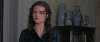 Movie still from “The Wings of the Dove” (1997), directed by Iain Softley – A woman with long brown curly hair stares into the camera; Close Up shot, Over the shoulder angle