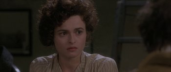 Movie still from “The Wings of the Dove” (1997), directed by Iain Softley – A young woman with curly brown hair sitting in a room; Close Up shot, Over the shoulder angle