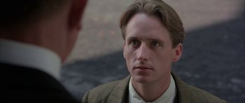 Movie still from “The Wings of the Dove” (1997), directed by Iain Softley – A person wearing a suit and tie; Close Up shot, Over the shoulder angle