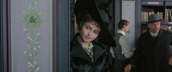 Movie still from “The Wings of the Dove” (1997), directed by Iain Softley – A young girl wearing a black hat and a black coat; Close Up shot, Over the shoulder angle