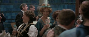 Movie still from “The Wings of the Dove” (1997), directed by Iain Softley – A group of people standing around each other holding wine glasses; Medium shot, Over the shoulder angle