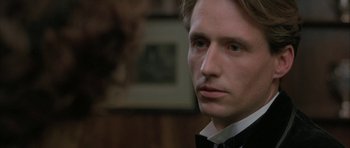 Movie still from “The Wings of the Dove” (1997), directed by Iain Softley – A person wearing a suit and bow tie; Close Up shot, Over the shoulder angle