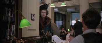 Movie still from “The Wings of the Dove” (1997), directed by Iain Softley – A woman wearing a hat and a fur coat in a room; Medium shot, Over the shoulder angle