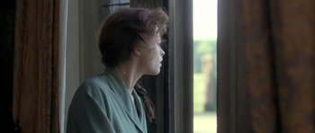 Movie still from “The Wings of the Dove” (1997), directed by Iain Softley – A woman in a green dress looking out a window; Close Up shot, Over the shoulder angle