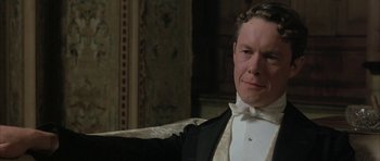 Movie still from “The Wings of the Dove” (1997), directed by Iain Softley – A person wearing a suit and bow tie; Close Up shot, Low angle