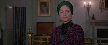 Movie still from “The Wings of the Dove” (1997), directed by Iain Softley – A woman with a green head covering and a purple jacket; Close Up shot, Over the shoulder angle