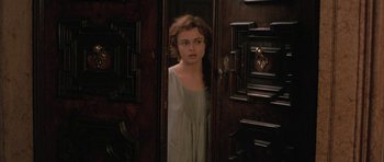Movie still from “The Wings of the Dove” (1997), directed by Iain Softley – A woman standing in front of an open door; Medium shot, High angle