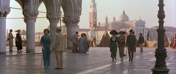 Movie still from “The Wings of the Dove” (1997), directed by Iain Softley – A group of people standing on a sidewalk near a building; Extreme Wide shot, High angle