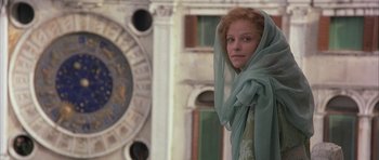 Movie still from “The Wings of the Dove” (1997), directed by Iain Softley – A woman in a green veil standing in front of a building; Medium shot, Low angle